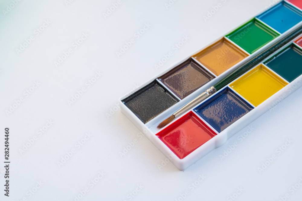 The complete set of water colour paints on a white background.Aquarelle colors in a plastic box. Different set of watercolors in palette.Copy space The complete set of water colour paints on a white background.Aquarelle colors in a plastic box. Different set of watercolors in palette.Copy space