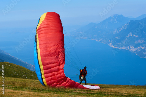 Paraglider starting to Paragliding above mountain Baldo over the Garda lake, Malcesine, Italy 