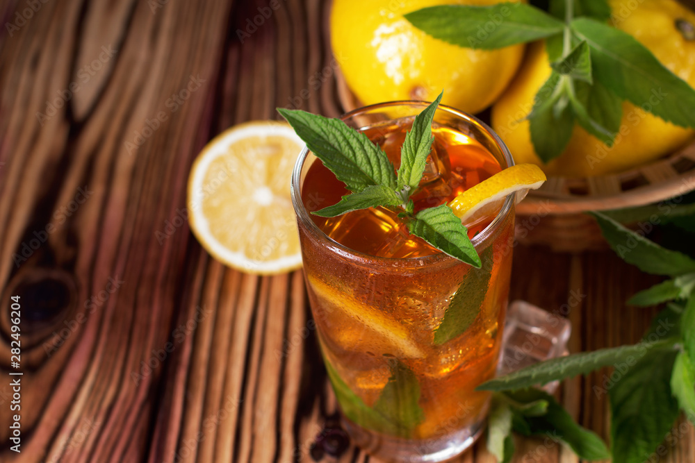 Glass of iced tea with mint and lemon. Cold drink. Rustic style Glass of iced tea with mint and lemon. Cold drink. Rustic style