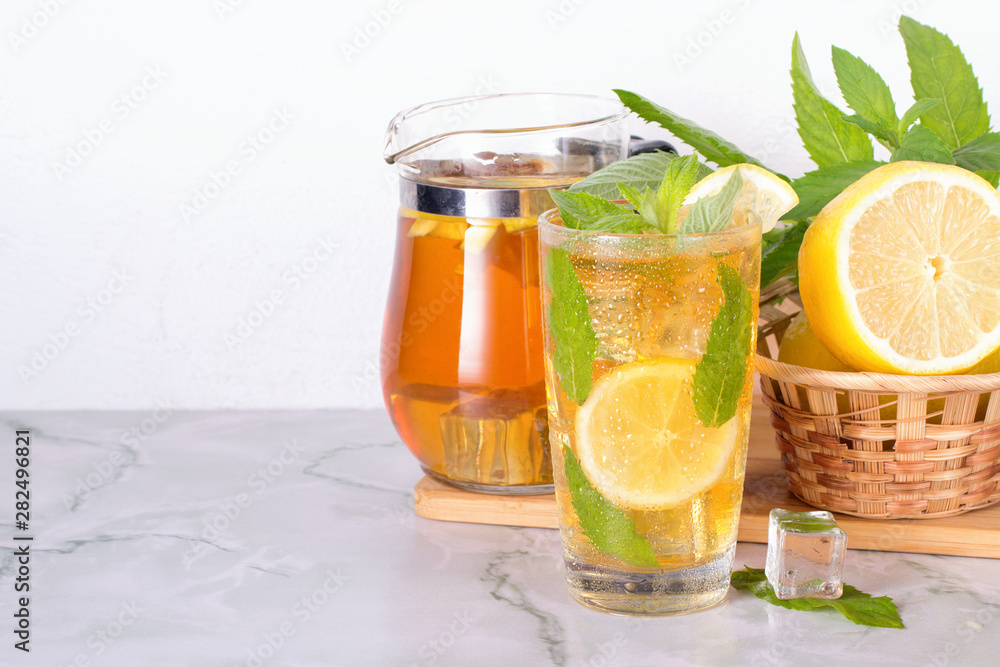 Glass of iced tea with mint and lemon on marble table. Cold drink. Glass of iced tea with mint and lemon on marble table. Cold drink.