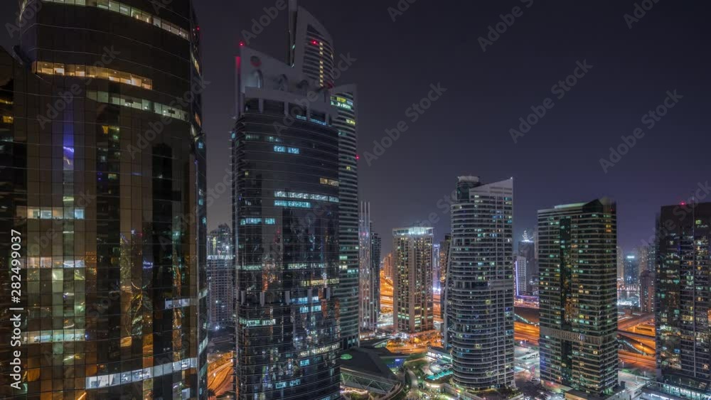 Residential and office buildings in Jumeirah lake towers district night timelapse in Dubai. Aerial panoramic view from above with modern skyscrapers Residential and office buildings in Jumeirah lake towers district night timelapse in Dubai. Aerial panoramic view from above with modern skyscrapers