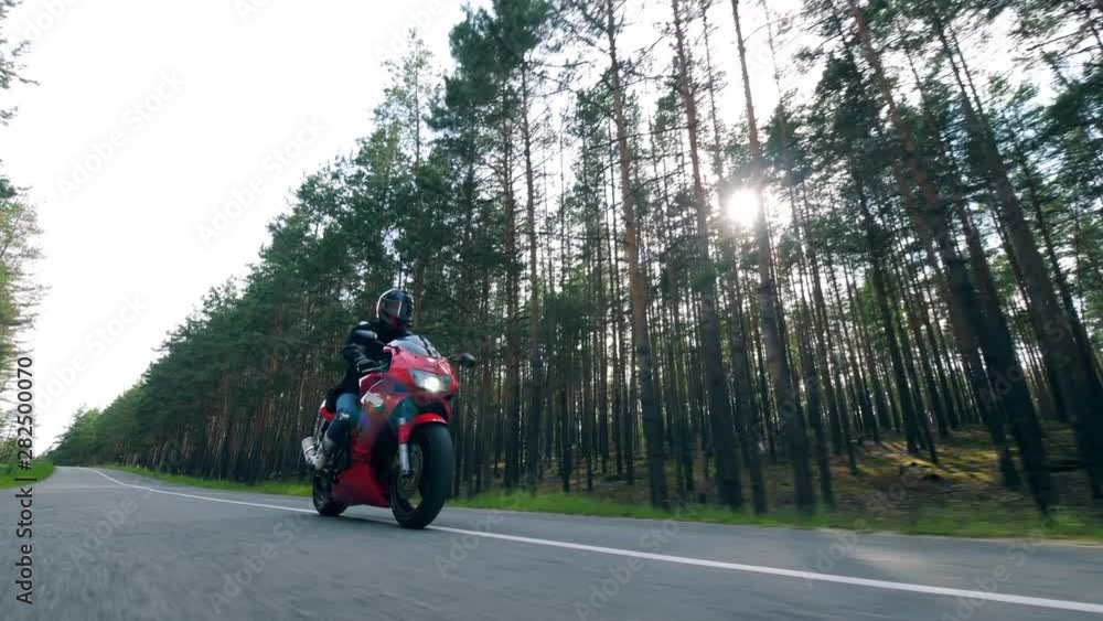Motorcyclist rides a bike, driving on a road. Motorcyclist rides a bike, driving on a road.