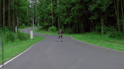 Wallpaper Mural TRACKING Caucasian female professional biathlete roller skiing uphill on a forest track during mid-season practice in summer. ARRI Alexa Mini with Cooke S4 prime lenses RAW graded footage Torontodigital.ca