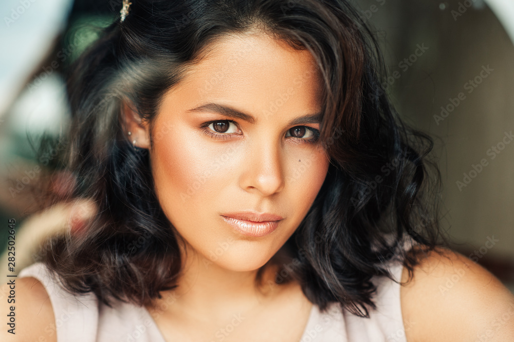 Close up portrait of beautiful young woman with professional makeup and hair styling, image taken through the window Close up portrait of beautiful young woman with professional makeup and hair styling, image taken through the window