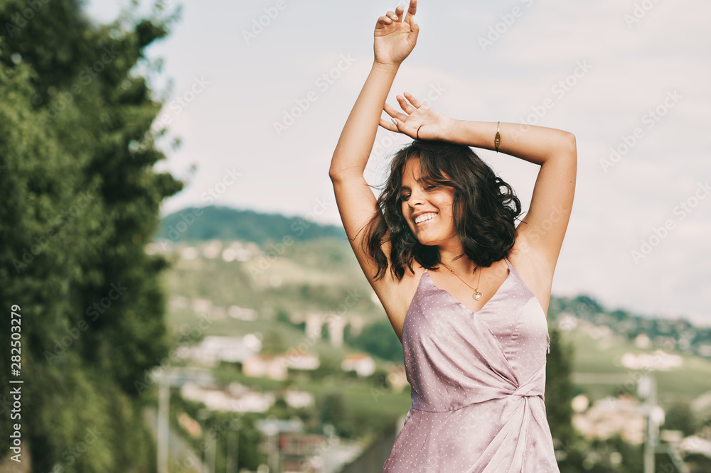 Happy young woman dancing on the street, wearing purple dress, happiness and freedom Happy young woman dancing on the street, wearing purple dress, happiness and freedom