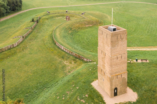 Monumental brick lighthouse or fire  light beacon called “Stenen Baak” or “Kogeloven” in Oostvoorne, Holland.  With trenches, 3 large cannons. a small gunpowder house in a grass field and walking path