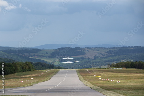 Motorflugzeug und Segelflugzeug beim starten von der Wasserkuppe in der Rhön photo