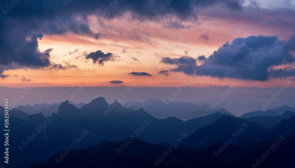 Austria alps view to germany. Mountain peaks at sunrise, dawn in twilight with fog and mist in the air. Tannheimer Tal valley near reutte in tyrol austria