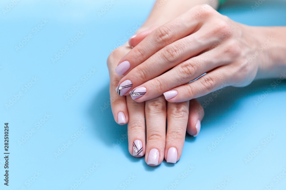 Fashionable female manicure, beautiful unique nail manicure on a blue background