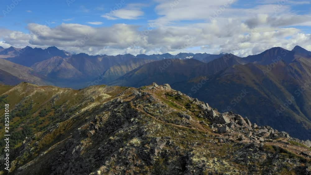 Aerial Forward: Top Of Rocky, Grassy Mountain With Mountains Out To Horizon And Blue Sky Above - Chugach National Forest, Alaska Aerial Forward: Top Of Rocky, Grassy Mountain With Mountains Out To Horizon And Blue Sky Above - Chugach National Forest, Alaska