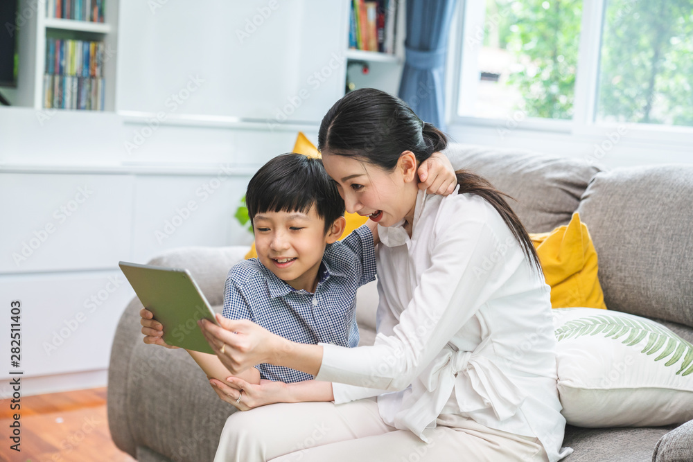 Family taking a selfie photo while sitting on sofa at home. mother and sons take a selfie with smartphone happy sitting on couch. Family taking a selfie photo while sitting on sofa at home. mother and sons take a selfie with smartphone happy sitting on couch.