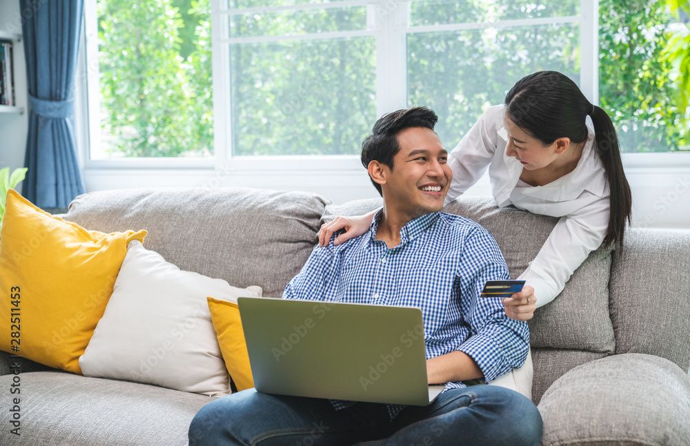 Happy Smiling Couple with Online Shopping Using Credit Card to Internet Shop on-line. Young couple with Laptop Computer and Credit Card buying online. Generation, relationship, modern technology. Happy Smiling Couple with Online Shopping Using Credit Card to Internet Shop on-line. Young couple with Laptop Computer and Credit Card buying online. Generation, relationship, modern technology.