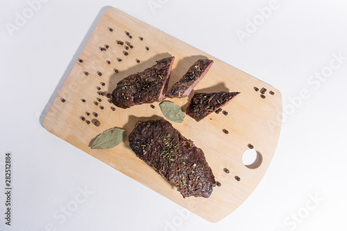 Juicy tasty piece of meat top view. Delicious juicy steak on wooden cutting board. A big piece of grilled meat.