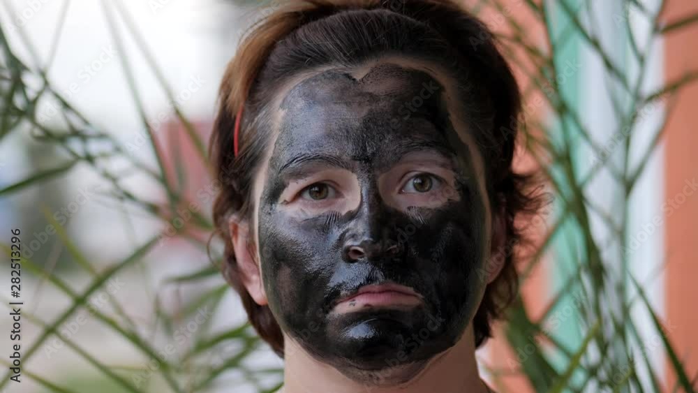 Female face covered with a black mask. Female face covered with a black mask.