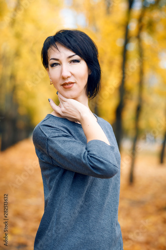 Beautiful woman posing in autumn city park, fall season, yellow leaves