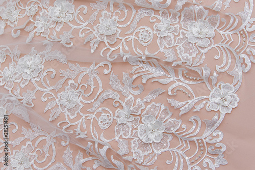 Texture lace fabric. lace on white background studio. thin fabric made of yarn or thread. a background image of ivory-colored lace cloth. White lace on beige background. © MartaKlos