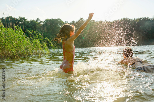 Mother and daughter swimming in lake photo