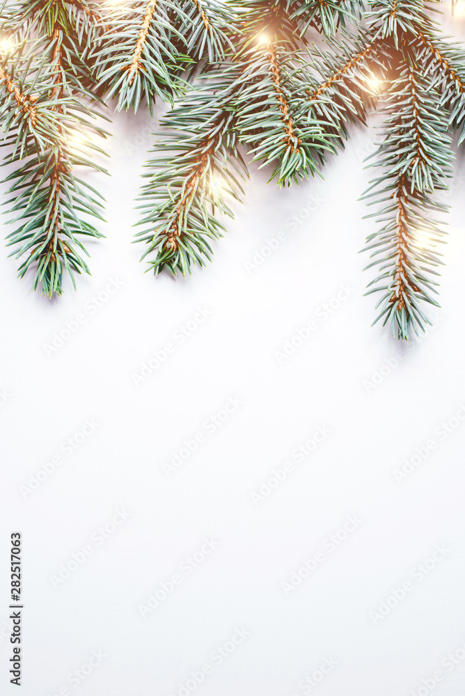 Fir branches on white wooden background. Christmas wallpaper. Flat lay, copy space.