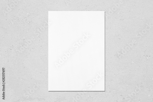 Fotografie Empty white vertical rectangle poster mockup with soft shadow on neutral light grey concrete wall background