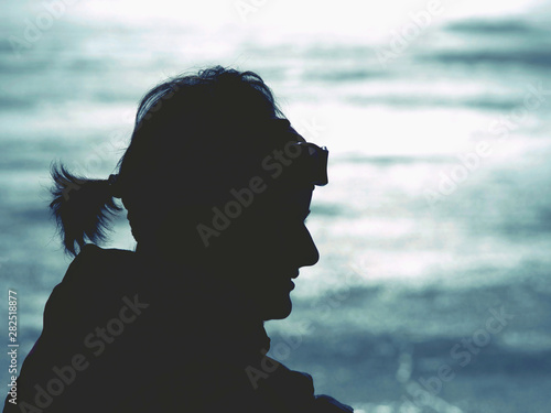Woman body outline in strong light from frozen lake.