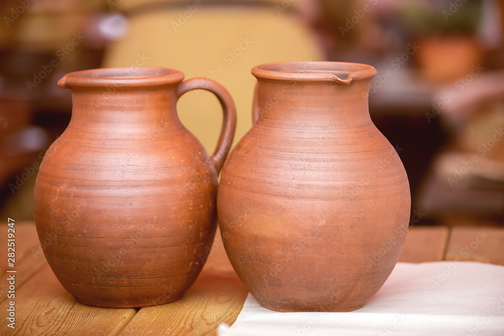 Two clay jars without frosting on the table at the fair of masters. Two clay jars without frosting on the table at the fair of masters.