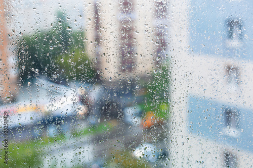 raindrops on window glass and blurred city street