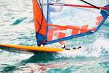 Windsurfing on Lake Garda. Unidentifiable Windsurfer Surfing The Wind On Waves, Recreational Water Sports, Selective focus