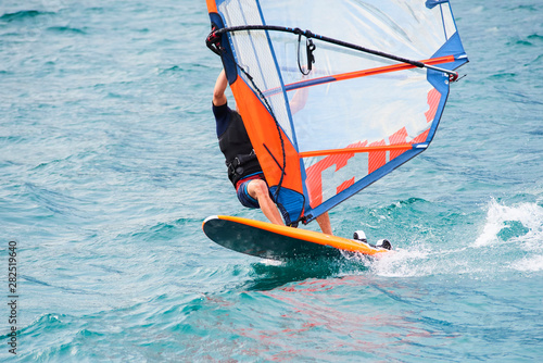 Windsurfing on Lake Garda. Unidentifiable Windsurfer Surfing The Wind On Waves, Recreational Water Sports, Selective focus