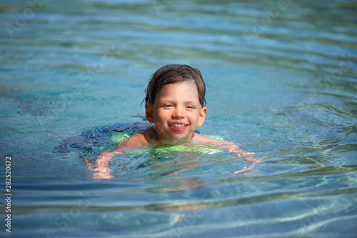 Ein Junge planscht in einem Swimmingpool