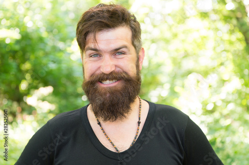 Guy relax in summer forest. Handsome man with beard and mustache summer vacation. Summer heat season concept. Wilderness survival guide. Man bearded hipster bright foliage background. Facial care