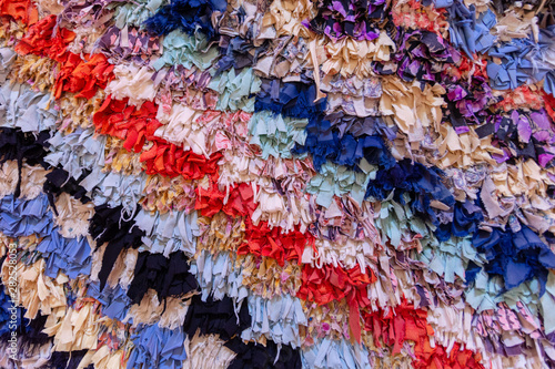 Background from diagonal multicolored stripes formed by interlacing a large number of small pieces of fabric of corresponding colors