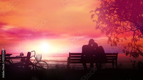 Couple on a bench watching the ocean sunset after a bike ride