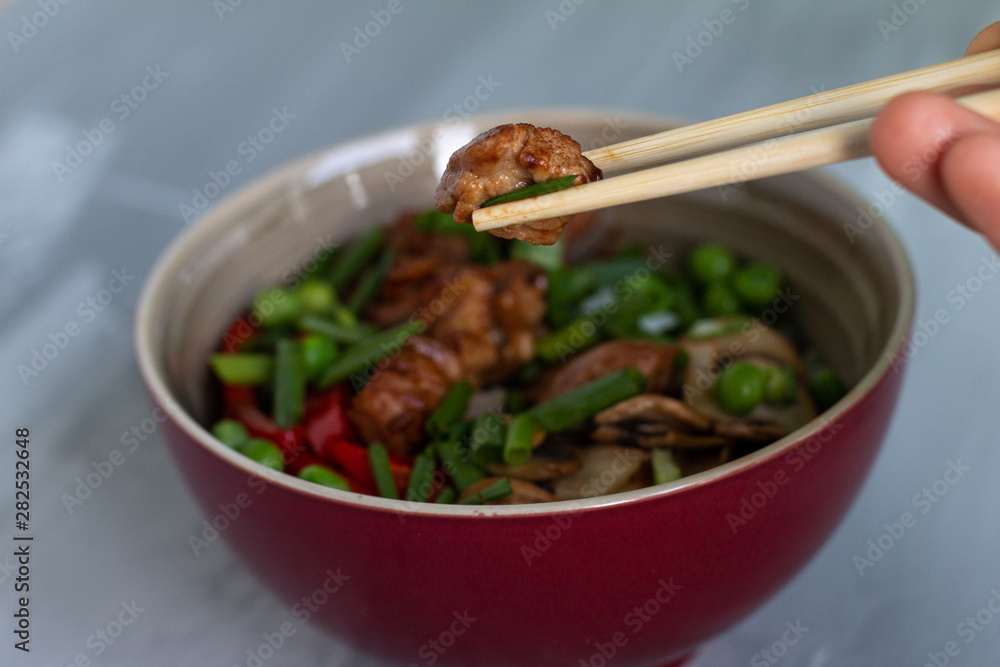 Traditional asian dish with rise and wok roasted meat, vegetables and mushrooms. Top view with space for text Traditional asian dish with rise and wok roasted meat, vegetables and mushrooms. Top view with space for text