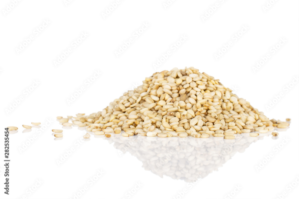 Lot of whole unpeeled sesame seeds isolated on white background