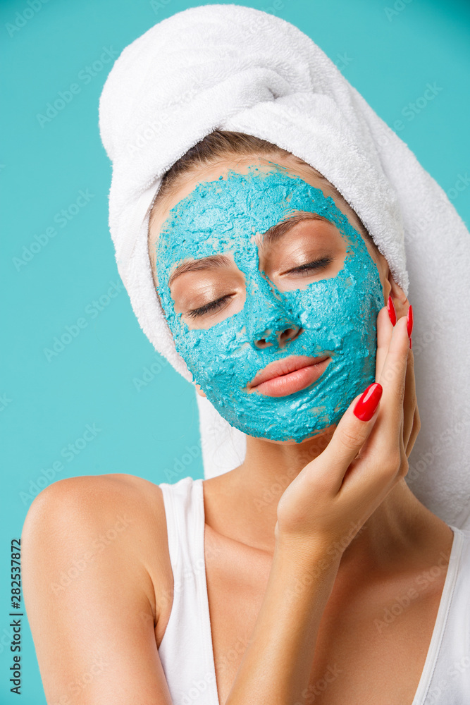 Beauty treatment - woman applying clay face scrub mask Beauty treatment - woman applying clay face scrub mask