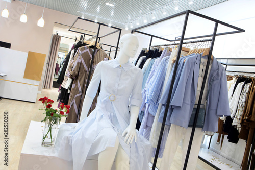Interior of clothing store .Bright interior.Minimalistic style.Clothes hang on hanger.Trendy colors