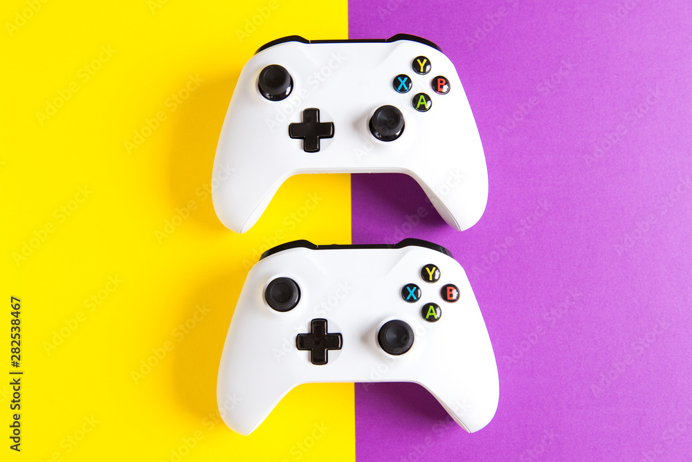 Computer gaming competition. Gaming concept. White joystick on yellow and purple background. Computer gaming competition. Gaming concept. White joystick on yellow and purple background.