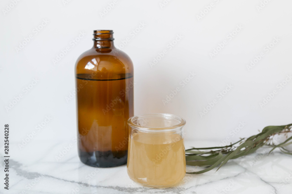 Amber Glass and Cup of Kombucha, Healthy Probiotic Drink, White and Marble Background, Copy Space Amber Glass and Cup of Kombucha, Healthy Probiotic Drink, White and Marble Background, Copy Space