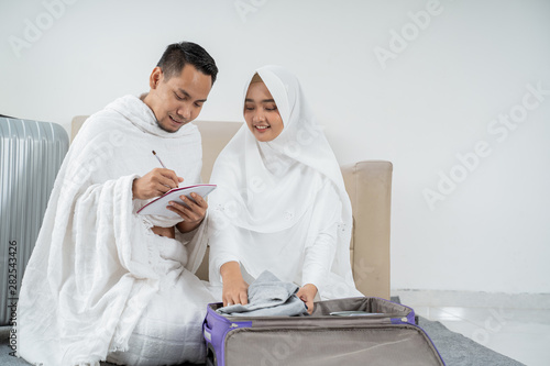 muslim pilgrims wife and husband prepare item for Hajj visiting Kaaba