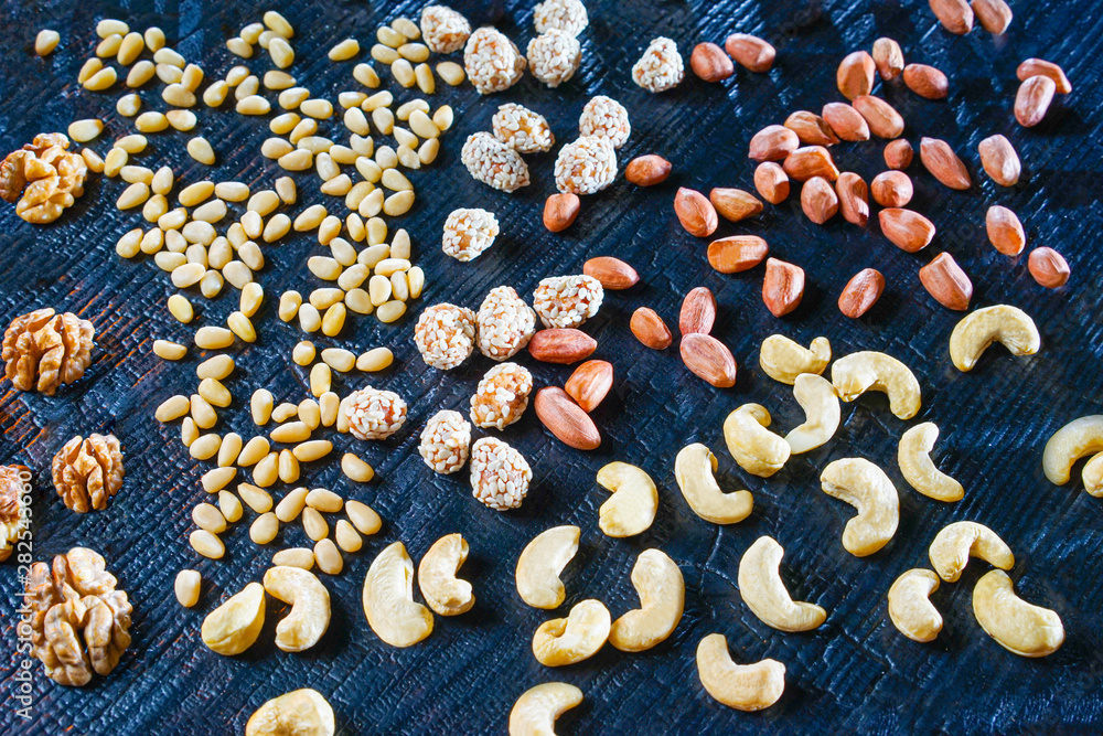 Nuts on blue background. Selling nuts. Cashew, peanuts, cedar and walnut on the table. Food industry. Snacks Nuts on blue background. Selling nuts. Cashew, peanuts, cedar and walnut on the table. Food industry. Snacks