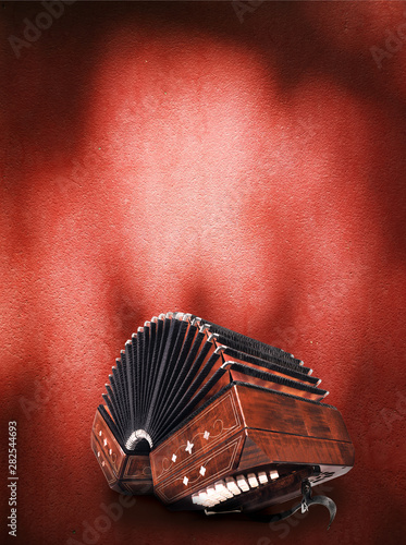 Foto Bandoneon, three quarters view on dark red background