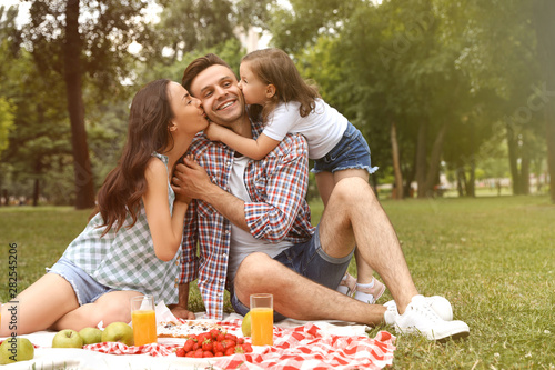Happy family having picnic in park on sunny day