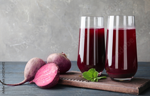 Composition with beet juice on table against grey background