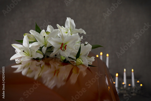 Carta da parati Wooden casket with white lilies in funeral home, closeup