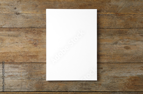 Stack of blank paper sheets for brochure on wooden background, top view. Mock up