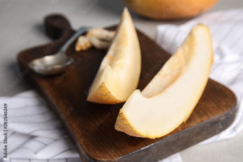 Wooden board with slices of ripe melon on table, closeup Wooden board with slices of ripe melon on table, closeup