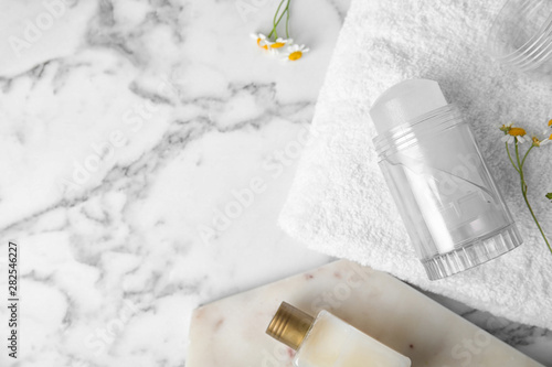 Flat lay composition with natural crystal alum deodorant and space for text on white marble table photo