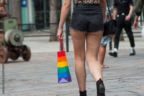 Closeup of mini jeans short on lesbian girl and rainbow bag  in the street photo