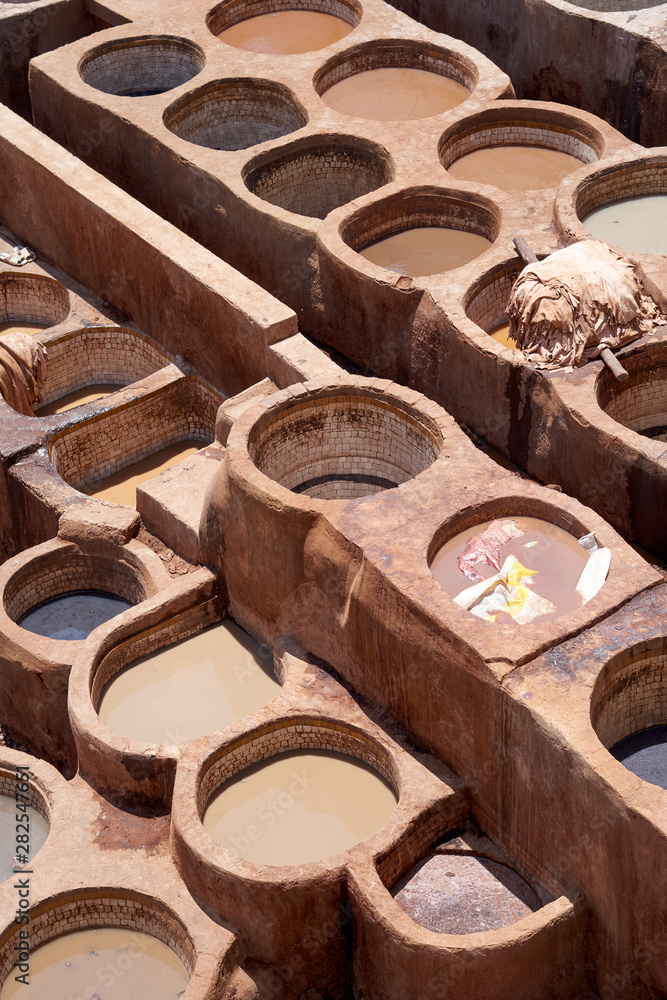 Stone vessels filled with a vast range of dyes in leather tanneries of Fez in Morocco.