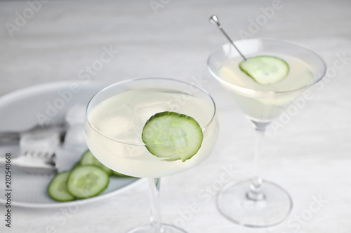 Glasses of tasty cucumber martini on grey table